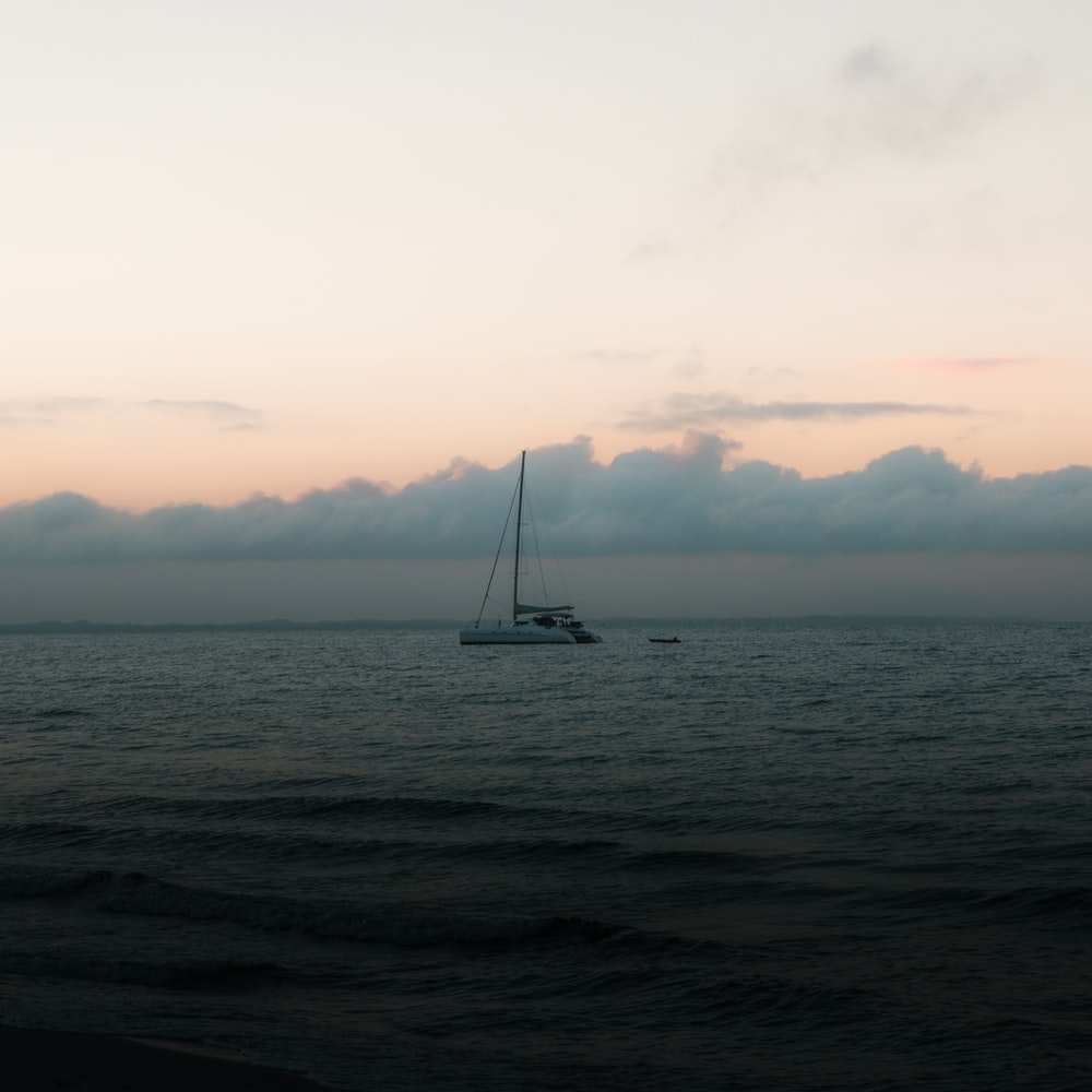 Sailboat On Sea Under White Sky During Daytime raster image