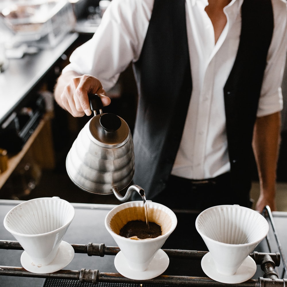 Person Pouring Coffee On White Ceramic Cup raster image