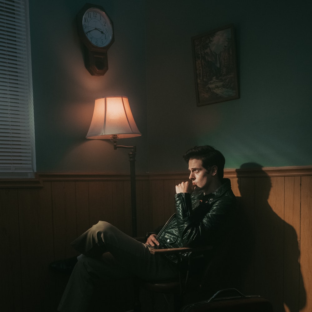 Man In Black Jacket Sitting On Chair