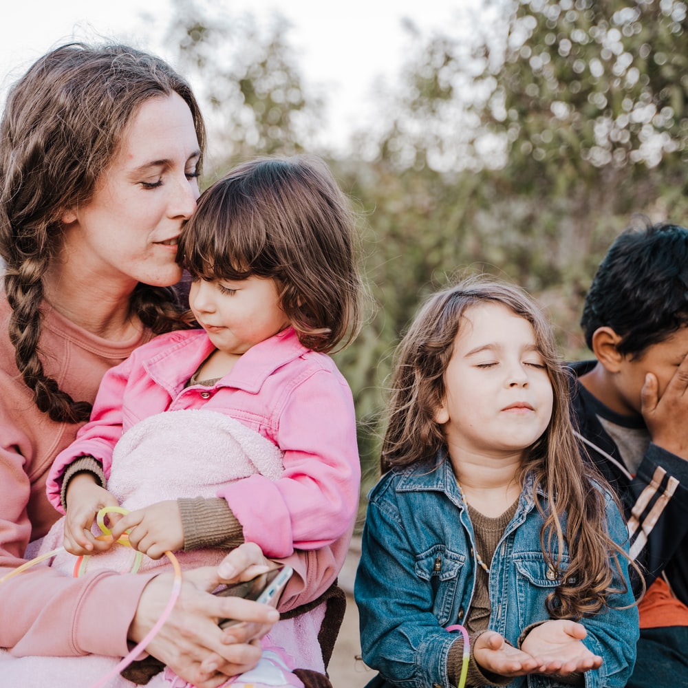 Woman In Blue Denim Jacket Carrying Girl In Pink Jacket During Daytime