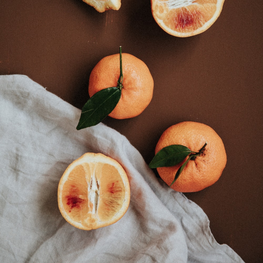 Sliced Orange Fruit On White Textile