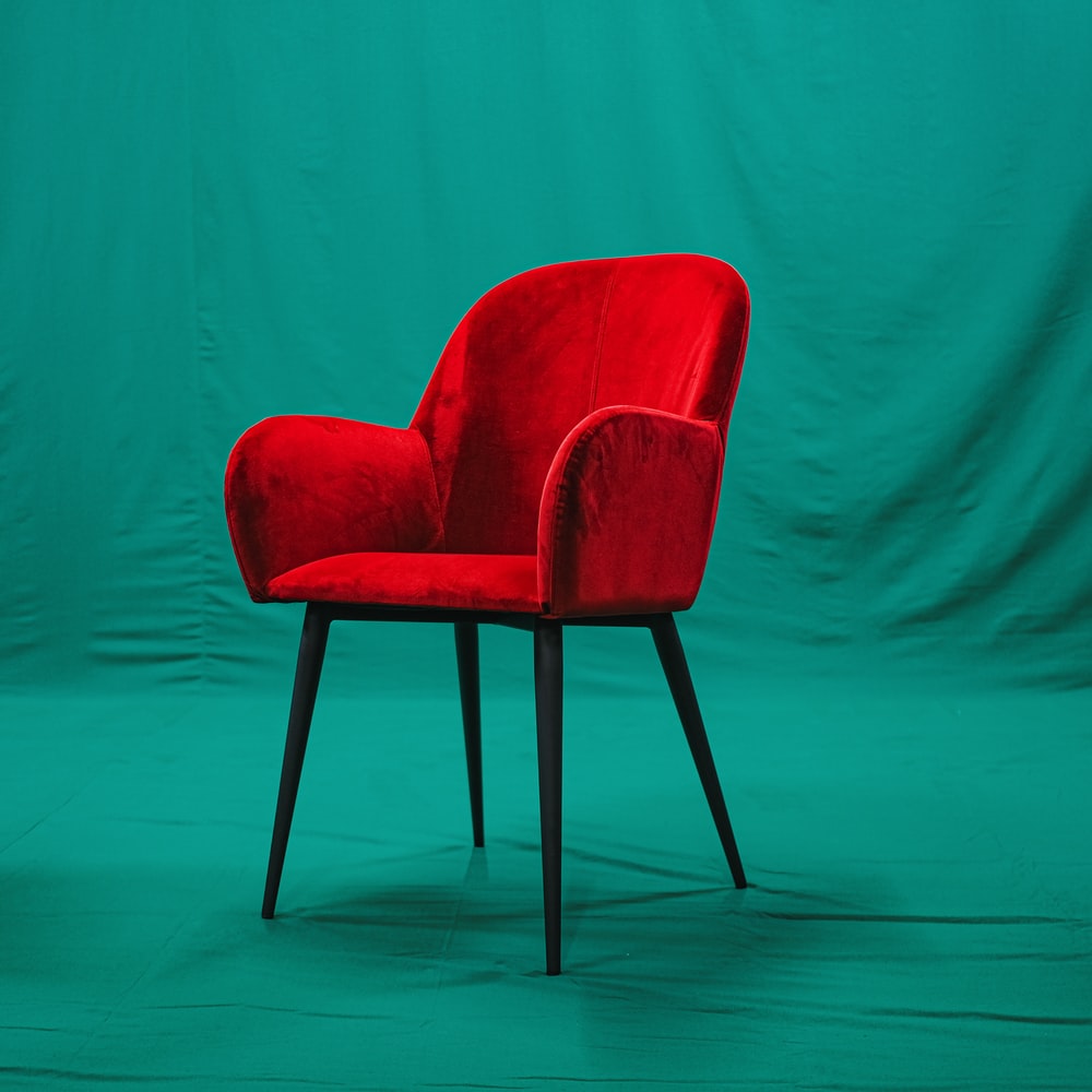 Red And Black Chair Beside Green Wall