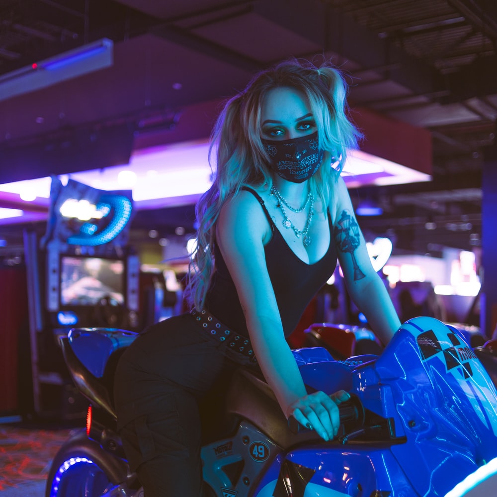 Woman In Black Tank Top And Black Pants Sitting On Blue Motorcycle