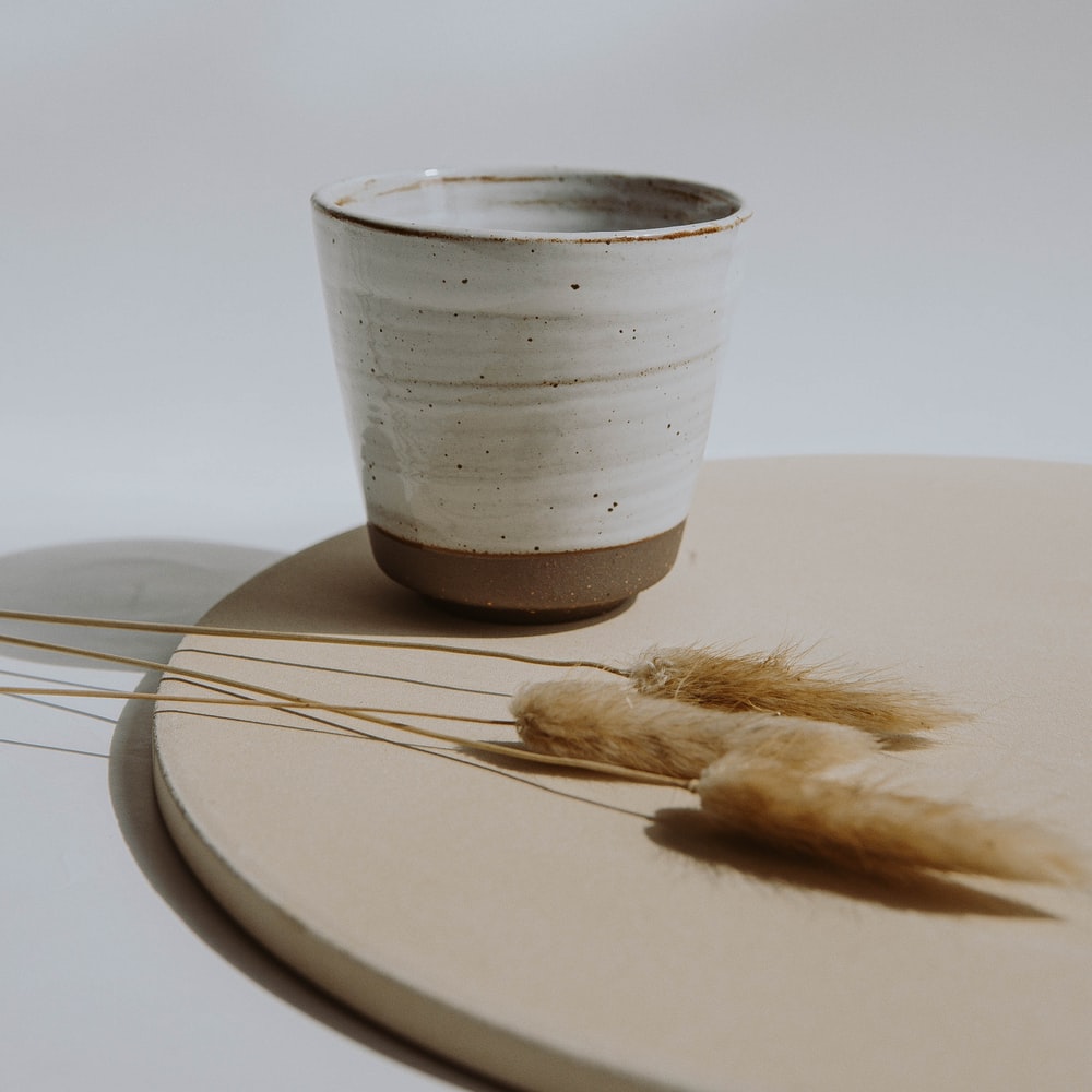 White And Silver Cup On Brown Wooden Table raster image