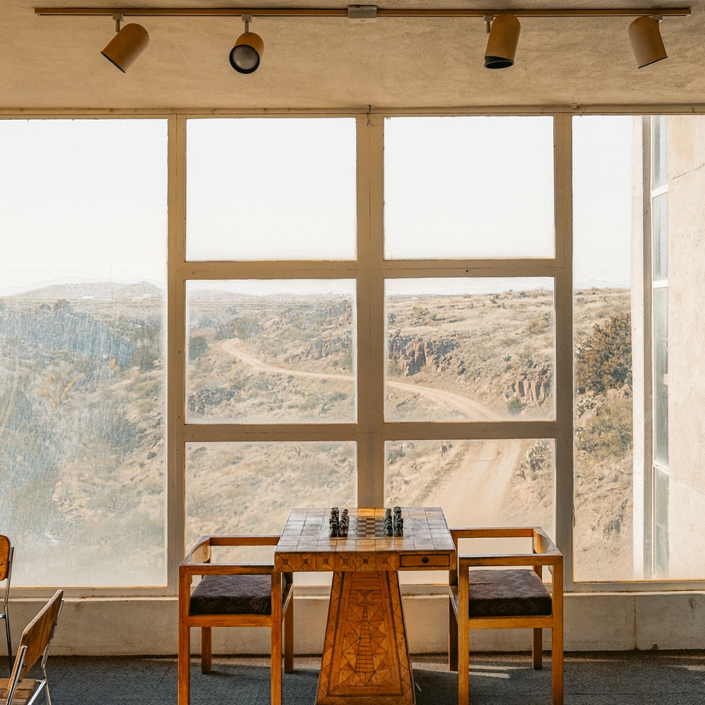 Brown Wooden Table And Chairs Near Window raster image