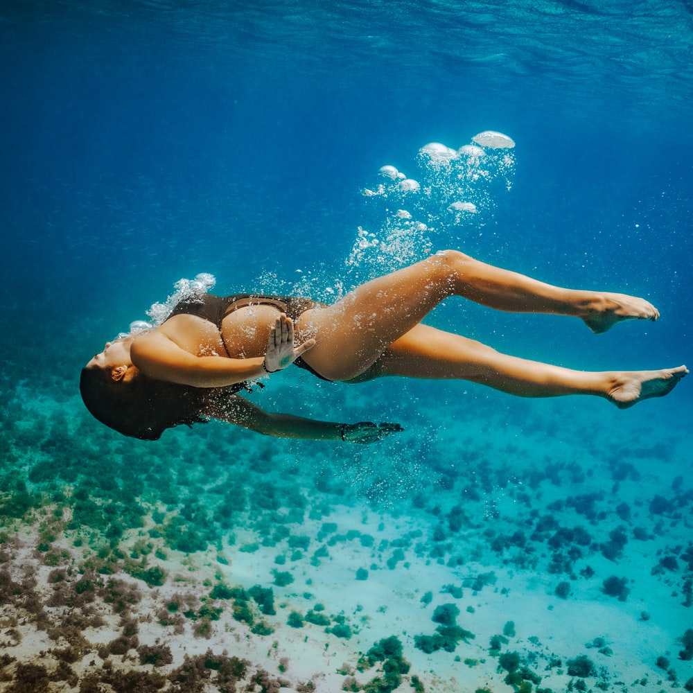 Woman In Blue Bikini Swimming In Water