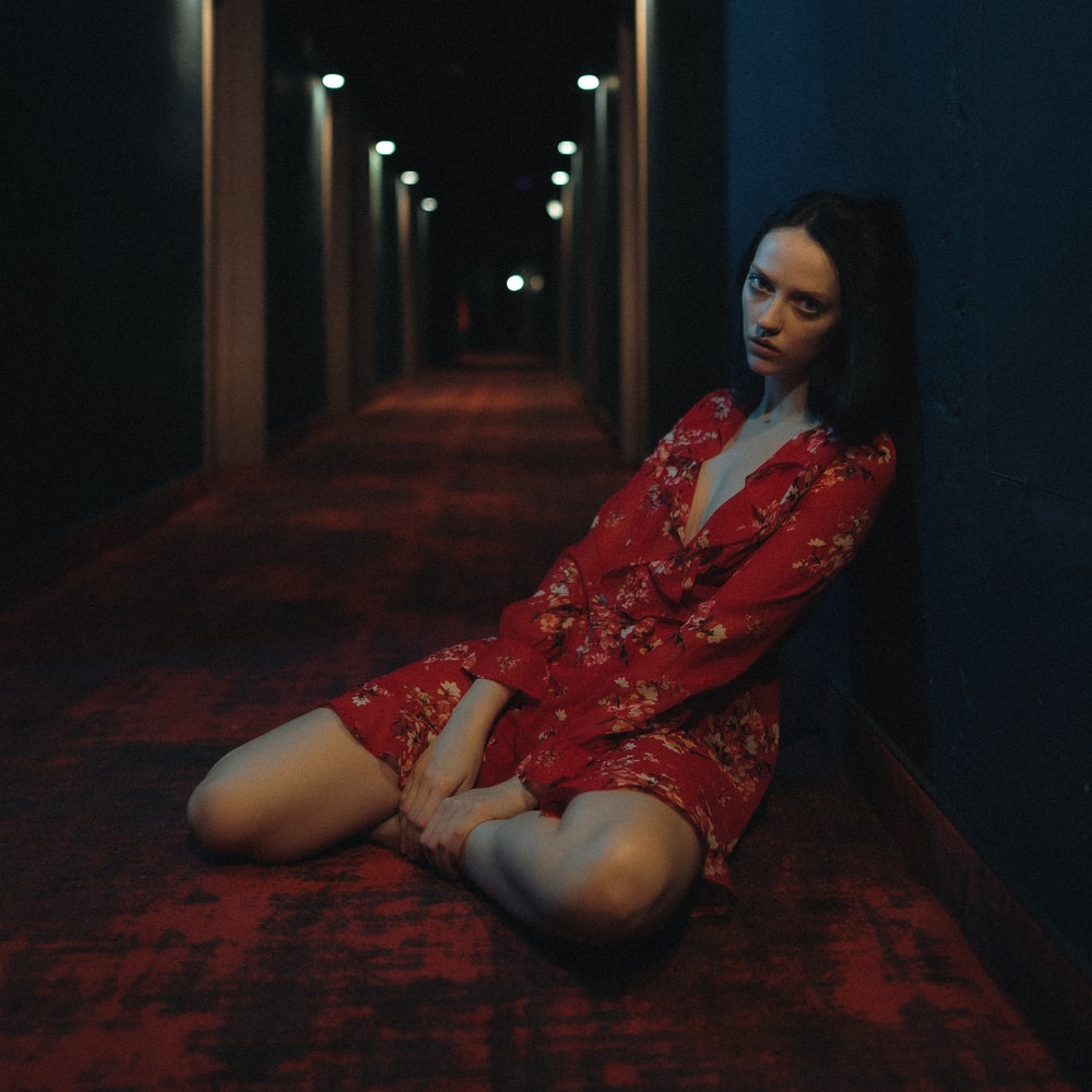 Woman In Red And White Floral Dress Sitting On Floor raster image