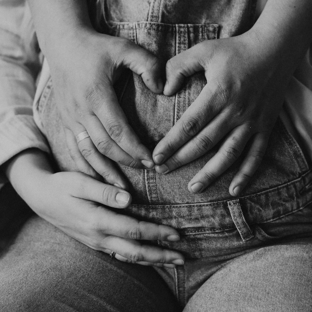 Grayscale Photo Of Woman Holding Her Stomach raster image