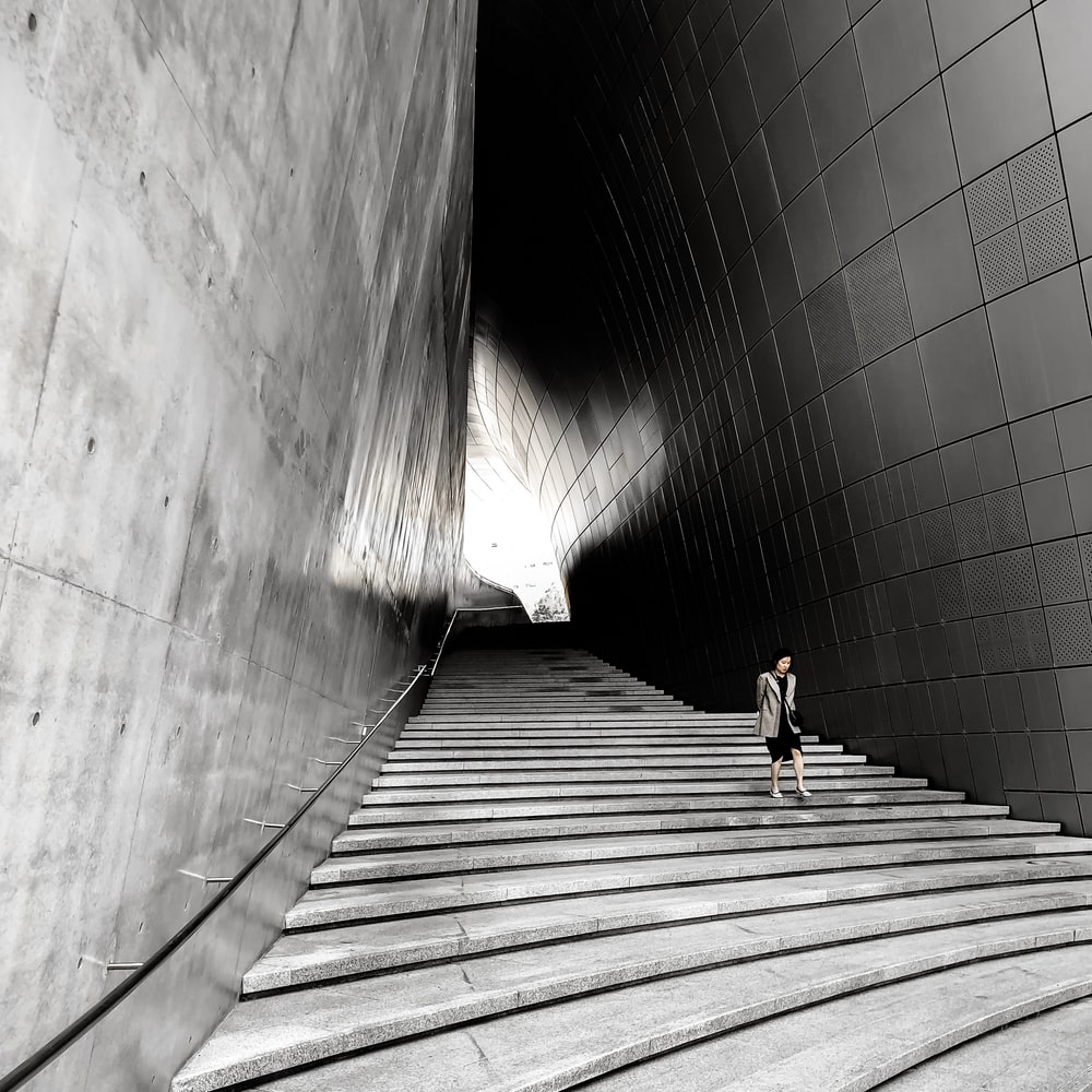 Woman In Black Shirt Walking On Gray Concrete Tunnel