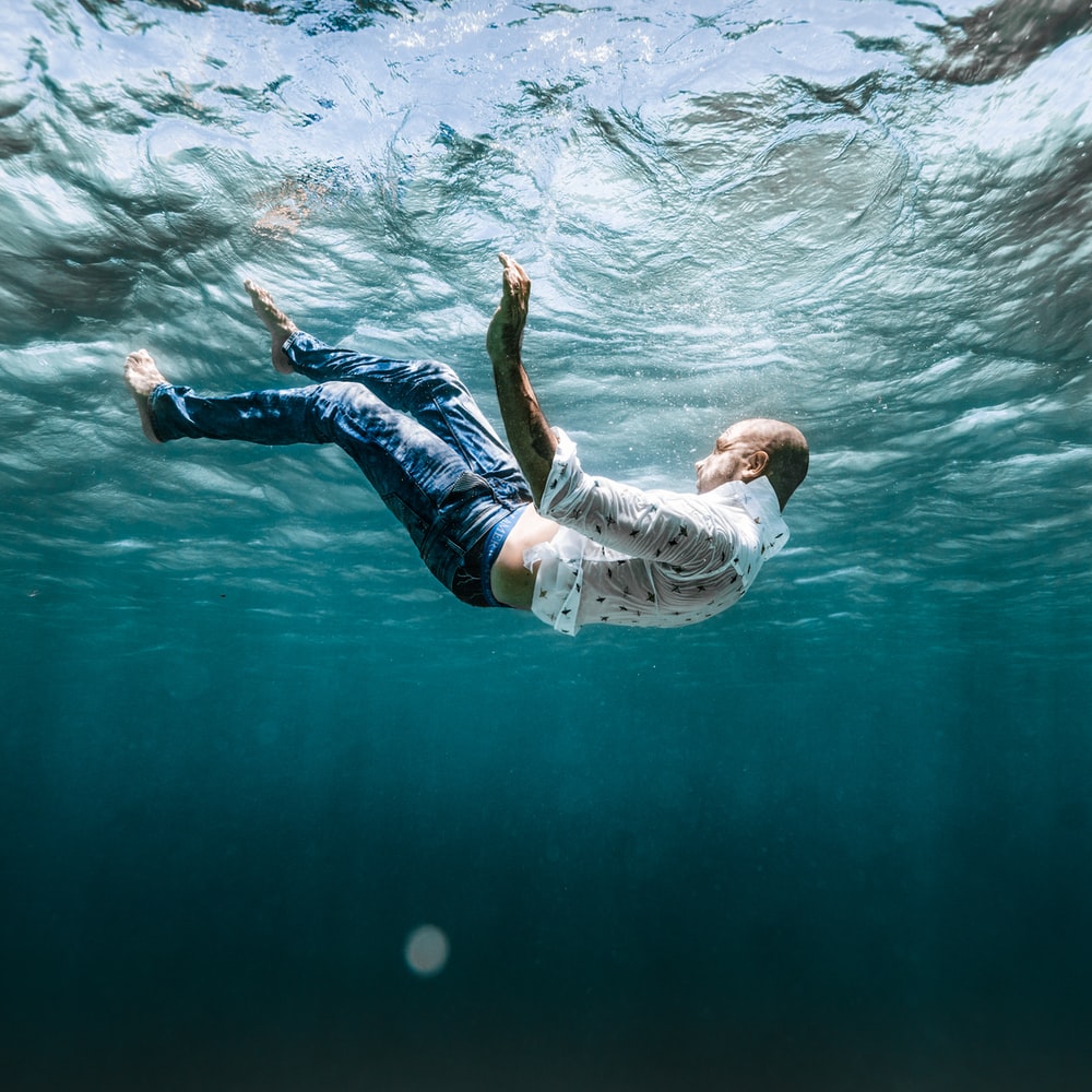 Man In White Shirt And Blue Denim Jeans Floating On Water raster image