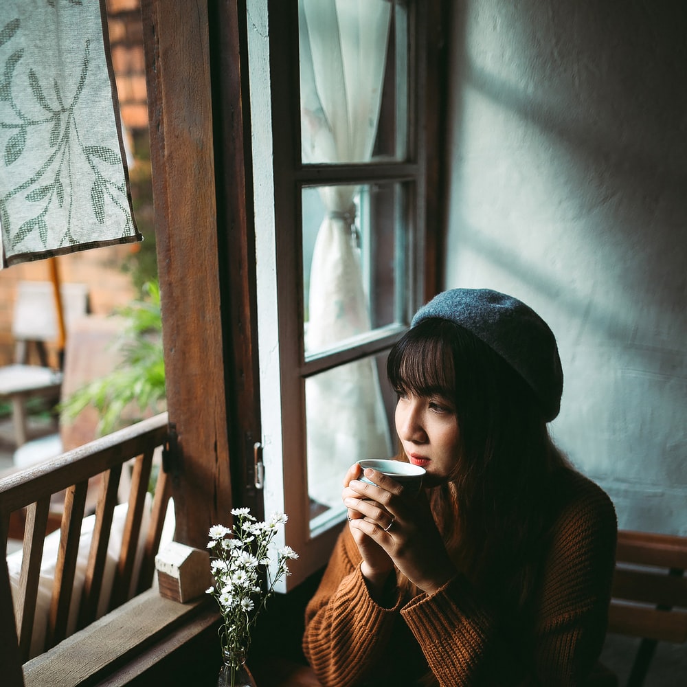 Woman In Black Knit Cap Sitting On Brown Wooden Chair raster image