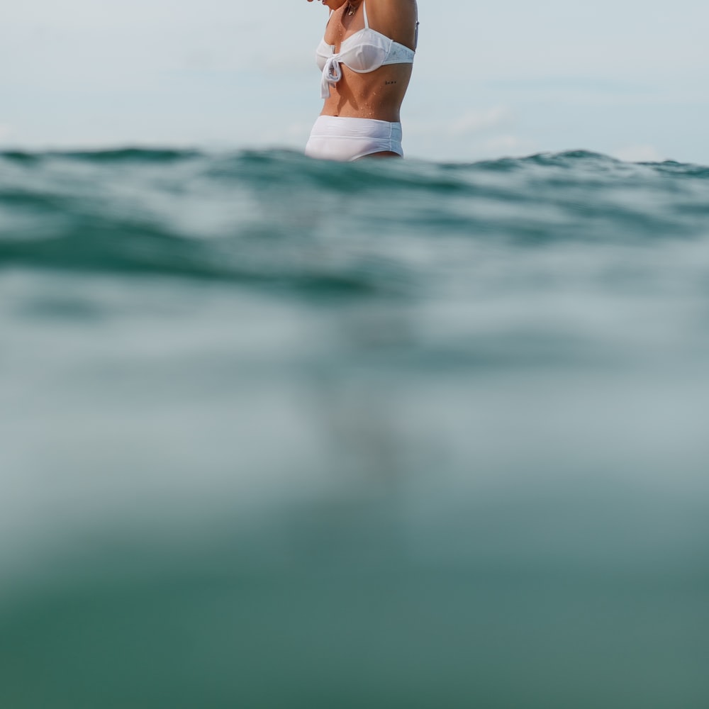 Woman In White Bikini Lying On Water During Daytime