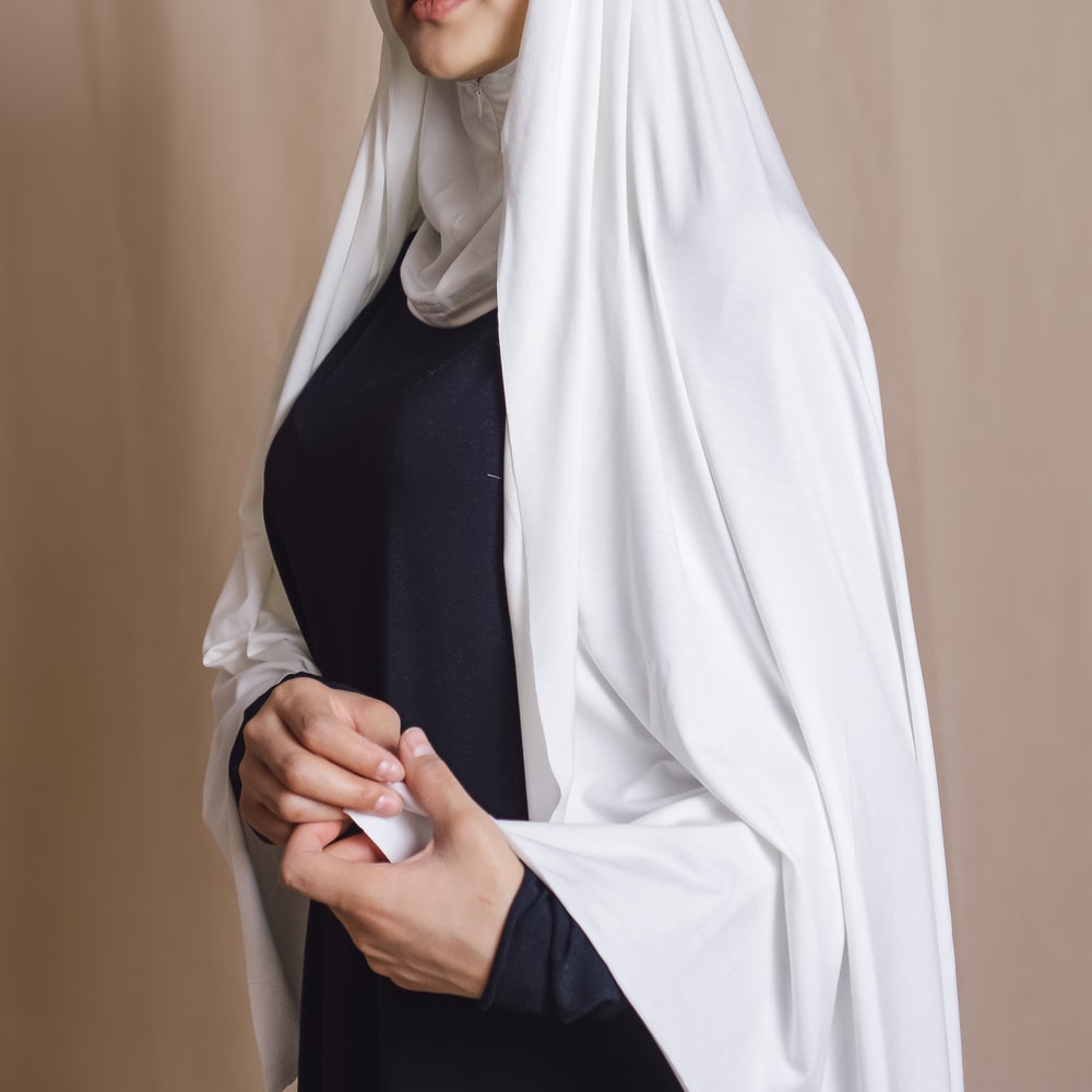 Woman In White Hijab Standing Near Beige Wall