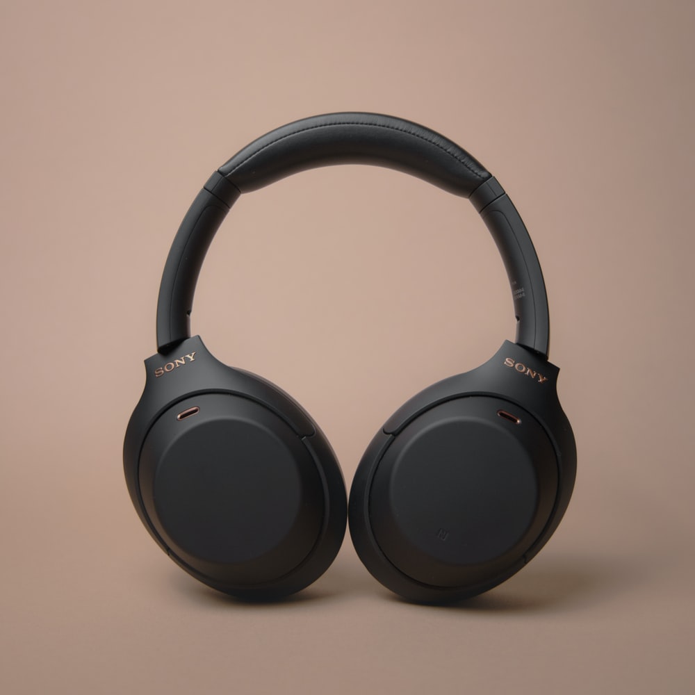 Black Wireless Headphones On White Table raster image