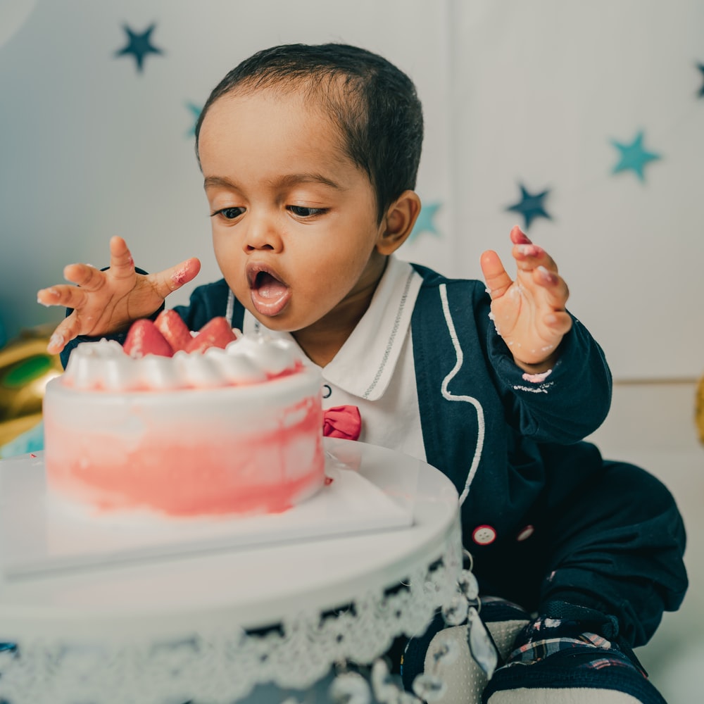 Boy In Black And White Jacket Holding Pink Cake