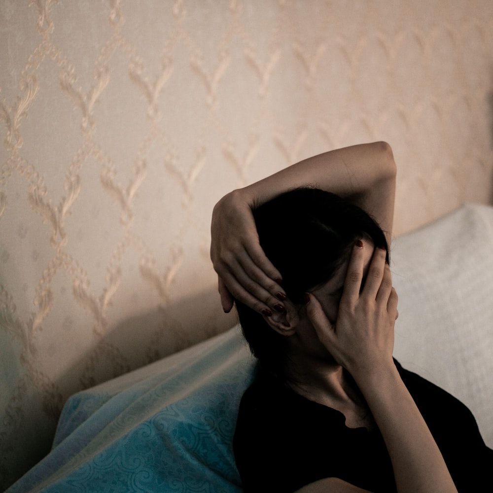 Woman In Black Shirt Covering Face With Blue Blanket