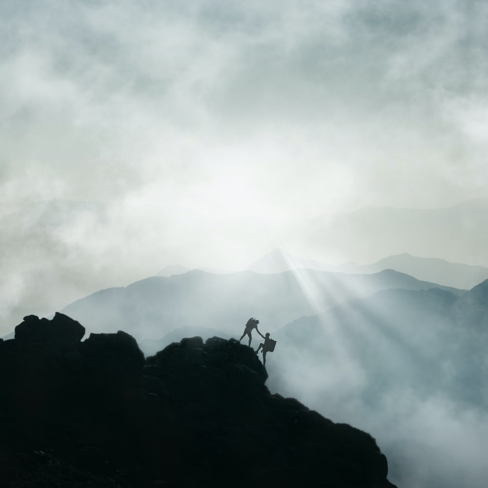 Silhouette Of Person Standing On Rock Formation During Daytime raster image