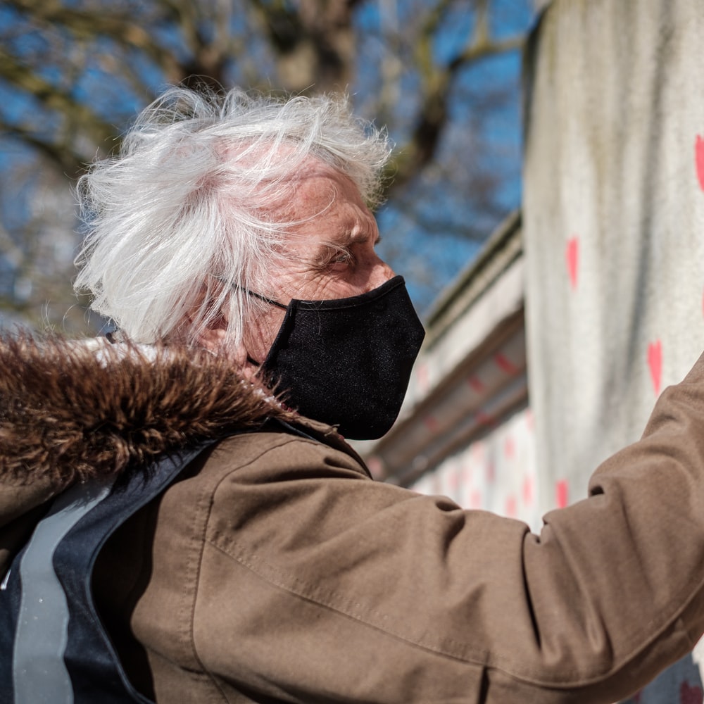 Man In Brown Jacket Holding Red Paint On White Wall