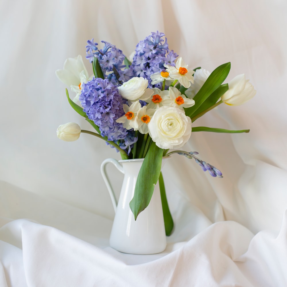 White And Purple Flower Bouquet In White Ceramic Vase