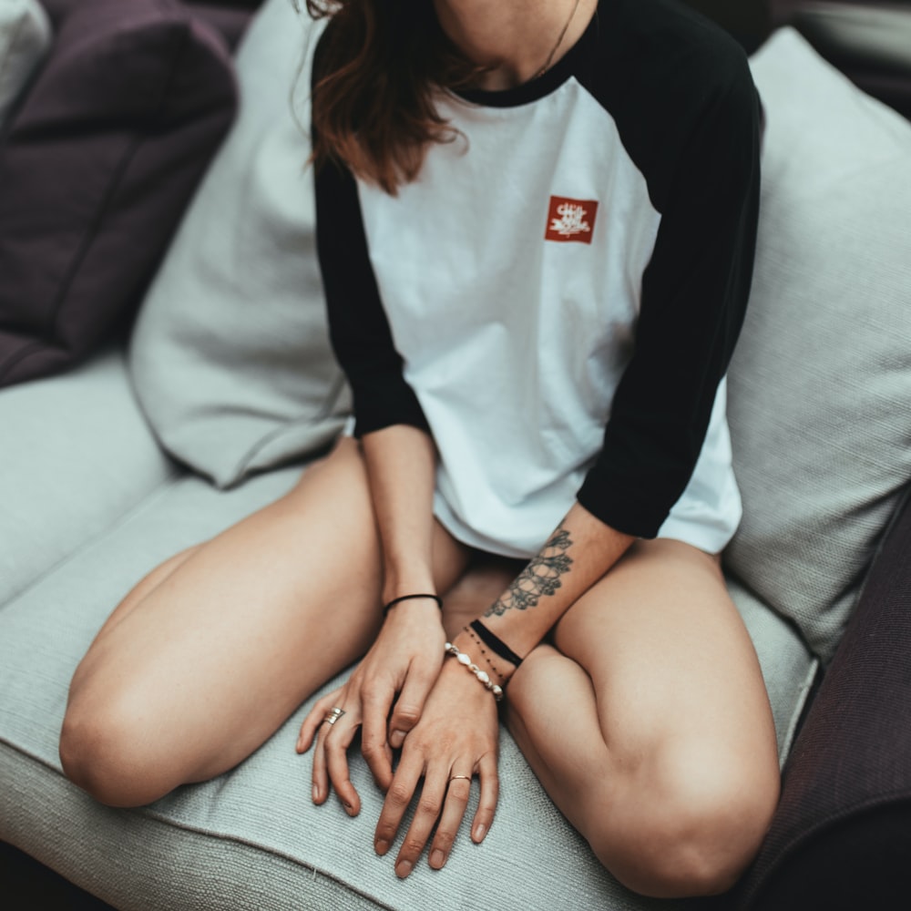 Woman In White And Black Long Sleeve Shirt Sitting On White Couch