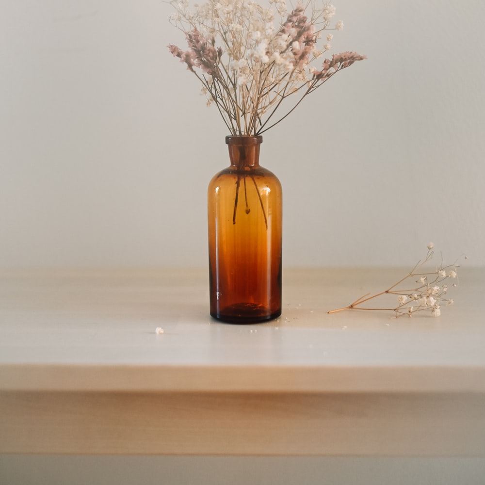 White Flowers In Brown Glass Bottle