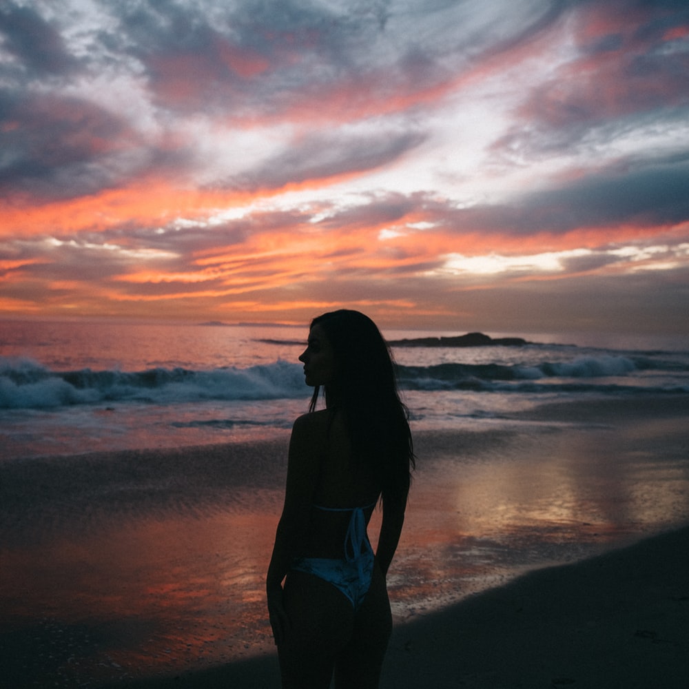 Woman In Black Bikini Standing On Beach During Sunset
