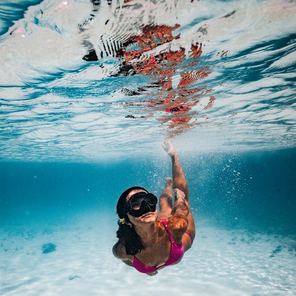 Woman In Pink Bikini Swimming In Pool During Daytime raster image