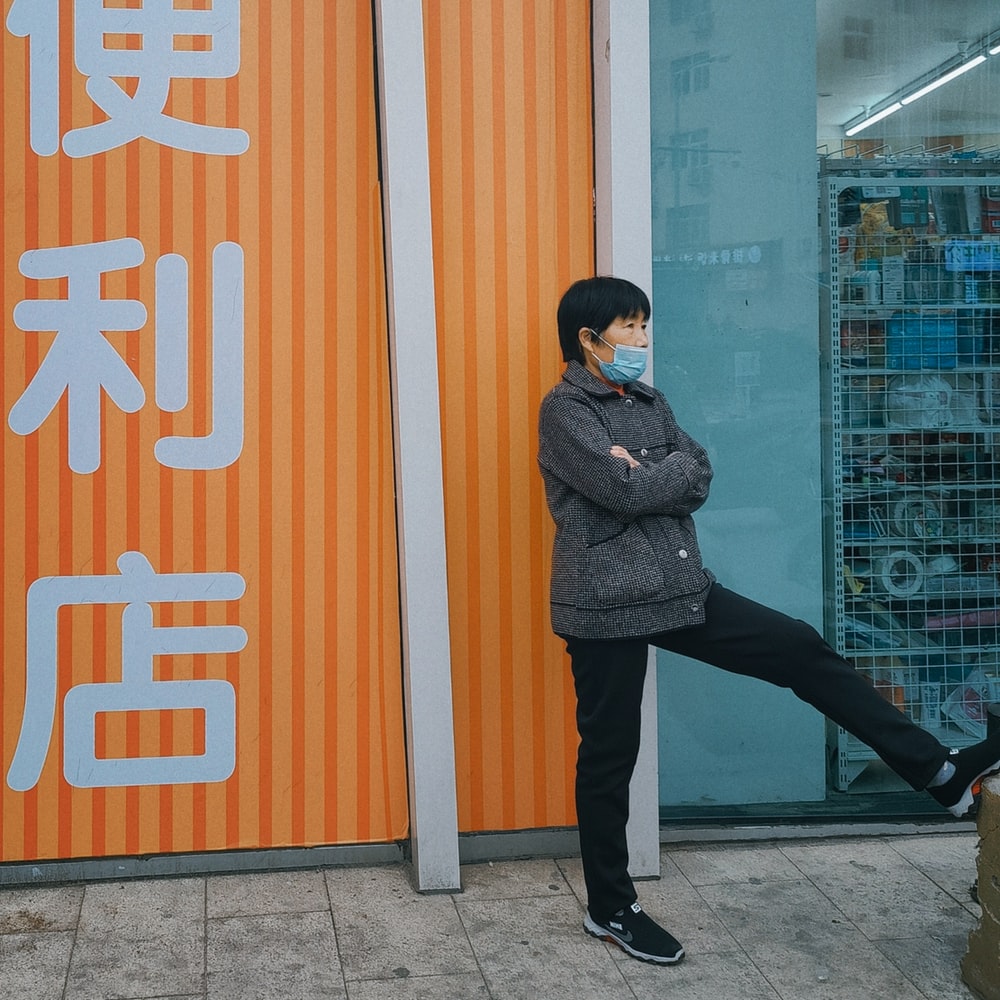 Woman In Black Coat Standing Beside Glass Wall raster image