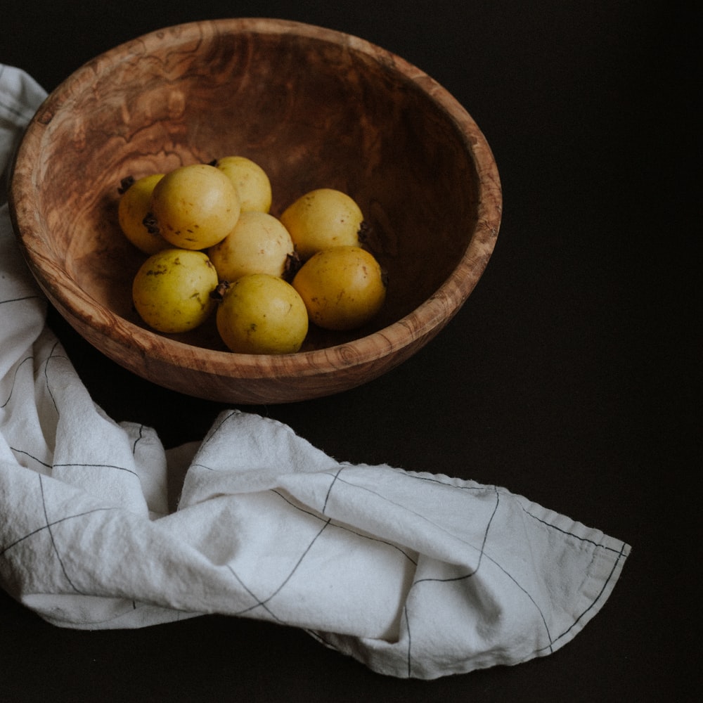 Yellow Round Fruits On Brown Wooden Bowl raster image